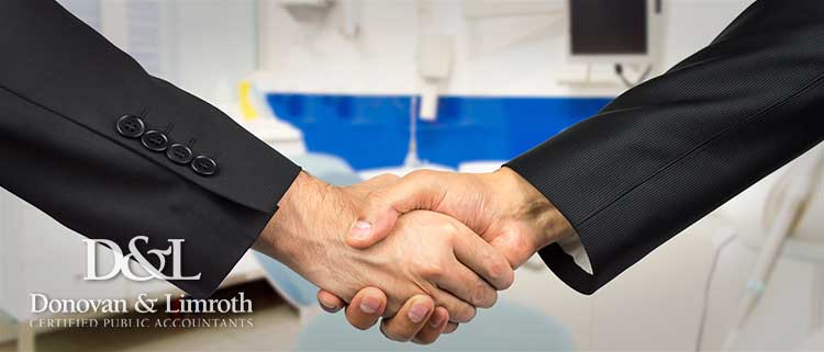 Business men shaking hands in dental office